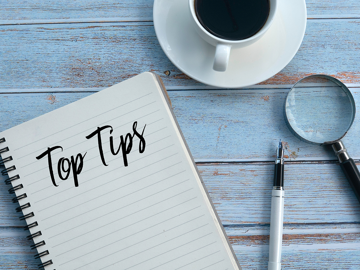 A cup of coffee and a notepad with the words "top tips" on it
