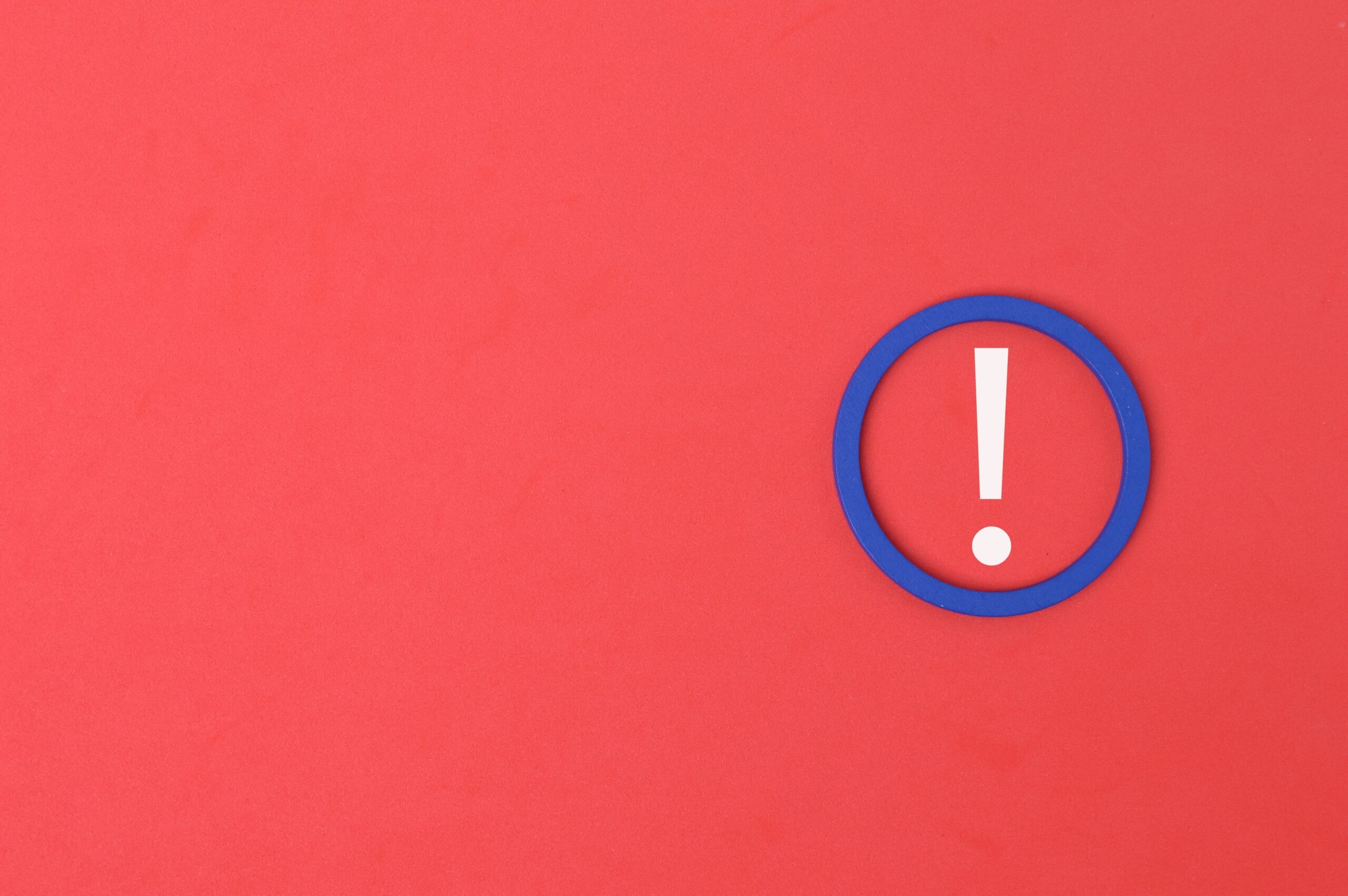 a red graphic with a white and blue exclamation mark warning symbol